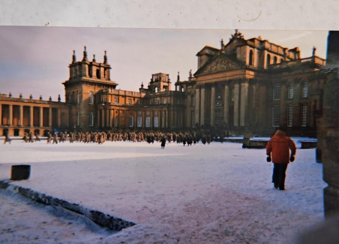 Blenheim Palace in the snow with a figure in a red coat